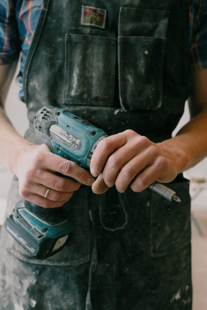 A person holding a drill in their hand.